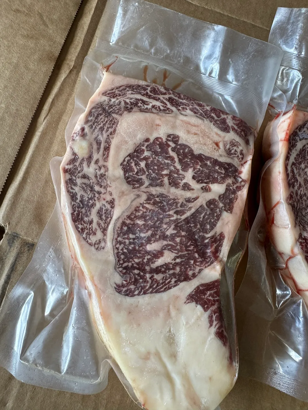 Close view of Fullblood Wagyu marbling through a vacuum-sealed steak